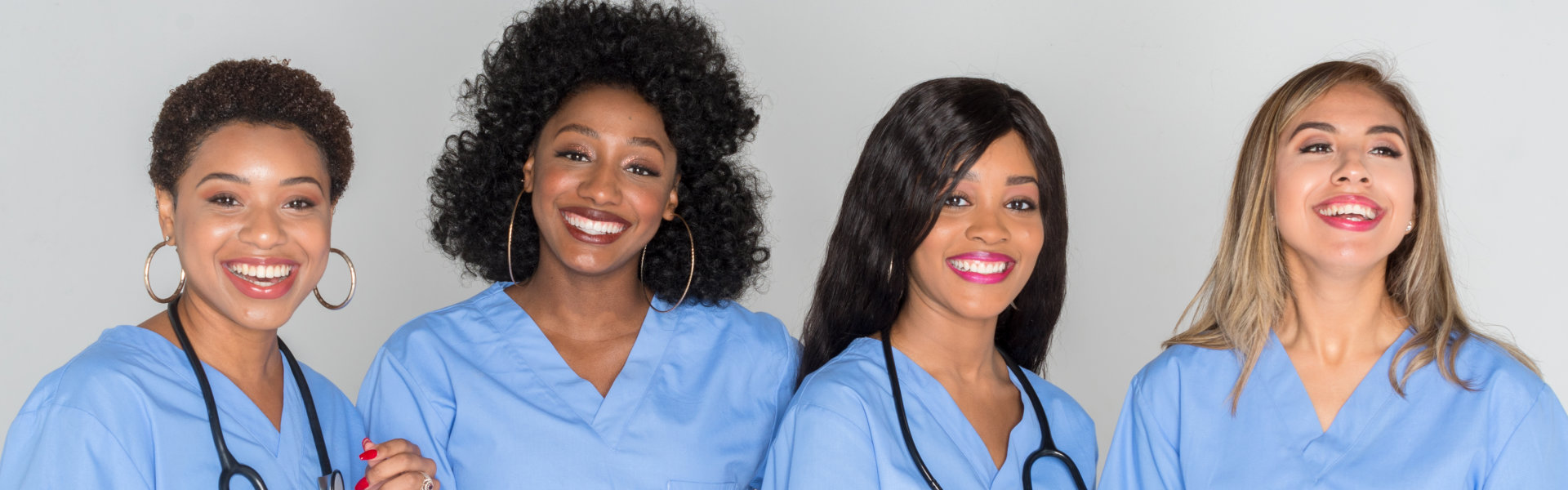 four female nurse pose at camera